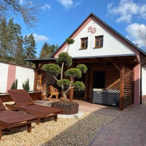 une terrasse avec deux bancs et une maison dans l'établissement SG Apartmán mezonetový s privátním wellness, à Nová Paka