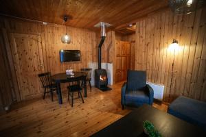 a living room with a table and chairs and a fireplace at Vesterland Feriepark Hytter, hotell og leikeland in Sogndal
