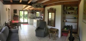 a kitchen and living room with a couch and a table at Maison de vacances village Océlandes in Saint-Julien-en-Born