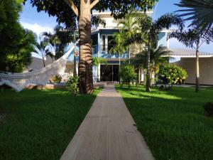 a walkway in front of a house with palm trees at Casa Porto Di Nassau in Porto Seguro