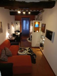 a living room with a red couch and a tv at Poppy's House in Casole dʼElsa