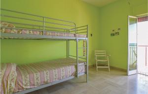 2 Etagenbetten in einem grünen Zimmer mit einem Stuhl in der Unterkunft Donna Mariangela in Caronia Marina