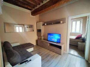 a living room with a television and a couch at Casa Toscanella & Girasole in Pescia