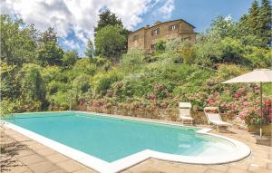 a swimming pool with two chairs and an umbrella at San Martin in Morra