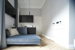 a living room with a blue couch and a kitchen at Fingerprint Luxury Apartments 3 in Zagreb
