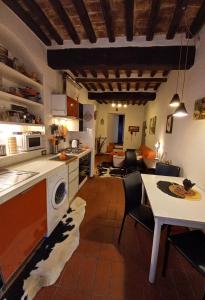 a kitchen and living room with a table and a dining room at Poppy's House in Casole dʼElsa
