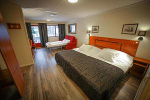 um quarto de hotel com uma cama e uma cadeira em Vesterland Feriepark Hytter, hotell og leikeland em Sogndal