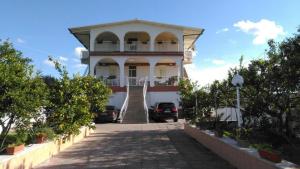 um grande edifício branco com uma escada que o leva até ele em Nido Verde em Agnone Bagni