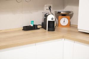 a kitchen counter with a coffee maker and a clock at Dimora Vanni "civico 5" "civico 9" in Polignano a Mare