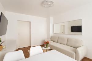 ハノーファーにあるDesign Apartment / 2 Room / Central / Contactless Check-inの白いリビングルーム(ソファ、テレビ付)