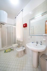une salle de bain blanche avec un lavabo et des toilettes dans l'établissement mi casa es tu casa, à San Vito Lo Capo