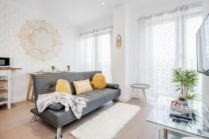 een woonkamer met een bank en een tafel bij Heliodoor Apartments St Albans City GREAT LOCATION Direct trains to London St Pancras 18 mins, Gatwick & Luton Airports in Saint Albans