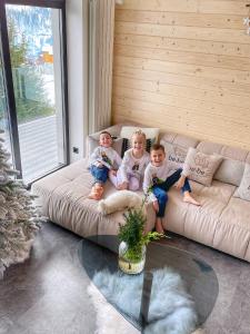 two children sitting on a couch in a living room at be be Chalet - premium jacuzi & private pool in Bukovel