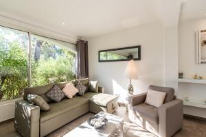 a living room with a couch and chairs and a window at Les Arcades de Cala Rossa in Lecci