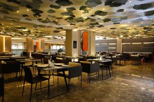 un restaurant avec des tables et des chaises ainsi qu'un plafond avec des plafonds à poissons dans l'établissement Grand Plaza Hotel - Jazan, à Jazan