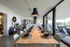 une salle à manger avec une grande table et des chaises en bois dans l'établissement Chambres d'Hôtes - La terrasse Bayehon - Ovifat, à Waimes