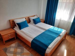 a bedroom with a large bed with blue pillows at Apartman Kovaci in Sarajevo