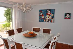 a dining room table with a bowl of fruit on it at Whales & Waves in Hermanus