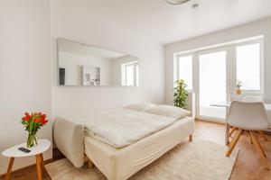 a white bedroom with a bed and a mirror at Design Apartment / 2 Room / Central / Contactless Check-in in Hannover