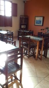 a dining room with wooden tables and wooden benches at Hostal La Casona in Pisco