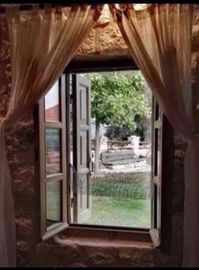 une fenêtre ouverte avec vue sur la cour dans l'établissement Elaion Guesthouse, à Ellinikó