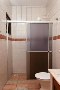 a shower with a glass door in a bathroom at Residencial Villa Luana in Garopaba