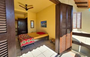 a bedroom with a bed and a ceiling fan at Residencial Villa Luana in Garopaba