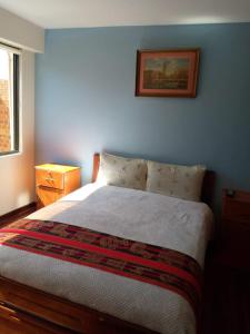 1 dormitorio con 1 cama y una foto en la pared en Hostal La Posada De La Abuela, en La Paz