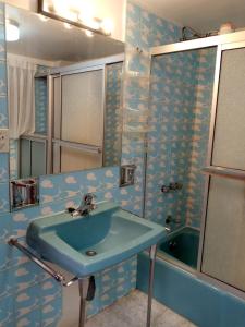 ein Badezimmer mit einem blauen Waschbecken und einer Badewanne in der Unterkunft Hostal La Posada De La Abuela in La Paz