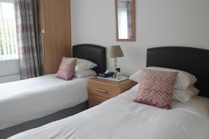 a hotel room with two beds and a window at The Meadows B&B in Armagh