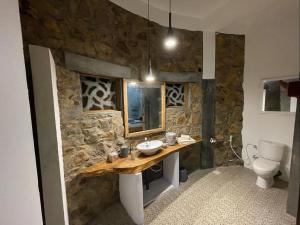 a stone bathroom with a sink and a toilet at Dune Towers in Alankuda