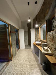 a bathroom with a stone wall and a sink at Dune Towers in Alankuda
