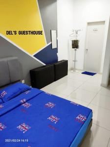 a bedroom with a bed with a blue comforter at Del’s Guesthouse @ Southville Same Level with Pool fits 8 in Bangi