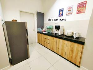 a kitchen with a counter and a refrigerator at Del’s Guesthouse @ Southville Same Level with Pool fits 8 in Bangi