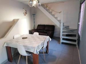 - Sala de estar con mesa y sillas y escalera en Maison entière, en Saint-Paul-les-Fonts