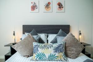um quarto com uma cama com um monte de almofadas em Croydon Saffron Mordern Apartment em Croydon