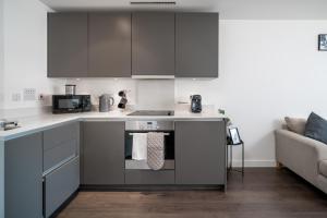 a kitchen with stainless steel appliances and a couch at Croydon Saffron Mordern Apartment in Croydon