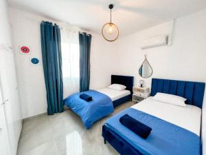 two beds in a room with blue curtains at LATSI BLUE 16 Brand new in Polis Chrysochous