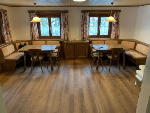 a dining room with two tables and chairs at Ferienhaus "frainerei" in Klösterle