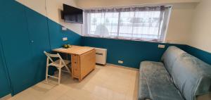 Habitación pequeña con escritorio, cama y mesa. en Studio Apartment between Nice and Cannes - Marina baie des Anges - Beach, restaurants, shops - tea/coffee/sugar/bed linen and towels, en Villeneuve-Loubet