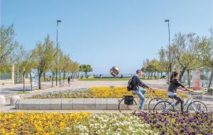 zwei Leute, die in einem Park Fahrrad fahren in der Unterkunft Stunning Home In Pesaro -Pu- With Wifi in Gradara