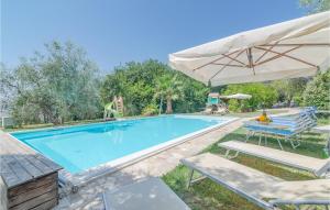una piscina con sombrilla y sillas y un parque infantil en Beautiful Home In Pesaro -pu- With Wifi, en Gradara