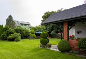 a house with a yard with bushes and trees at Magma Grzybowo in Grzybowo