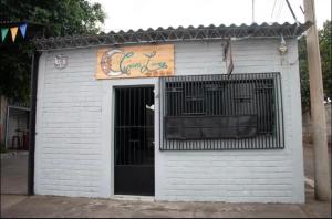 ein kleines weißes Gebäude mit einem Schild drauf in der Unterkunft Hostal Casa Luna in Santa Ana