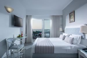 a hotel room with a bed and a balcony at Rethymno Mare Royal & Water Park in Skaleta +68 photos