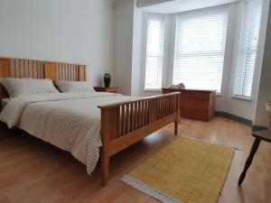 a bedroom with a large bed and two windows at The Annex Dymchurch in Dymchurch