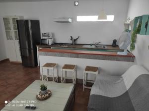 a kitchen with a sink and a counter with stools at Casa Baro in Zahora