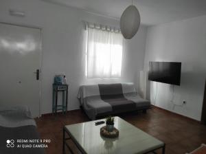 1 dormitorio con cama, mesa y TV en Casa Baro en Zahora