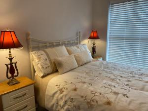 una camera da letto con un letto con due lampade e una finestra di Duiche an Rí - Delightful Village Home a Tipperary