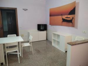 a room with a table and chairs and a tv at Darecco house in Cesenatico